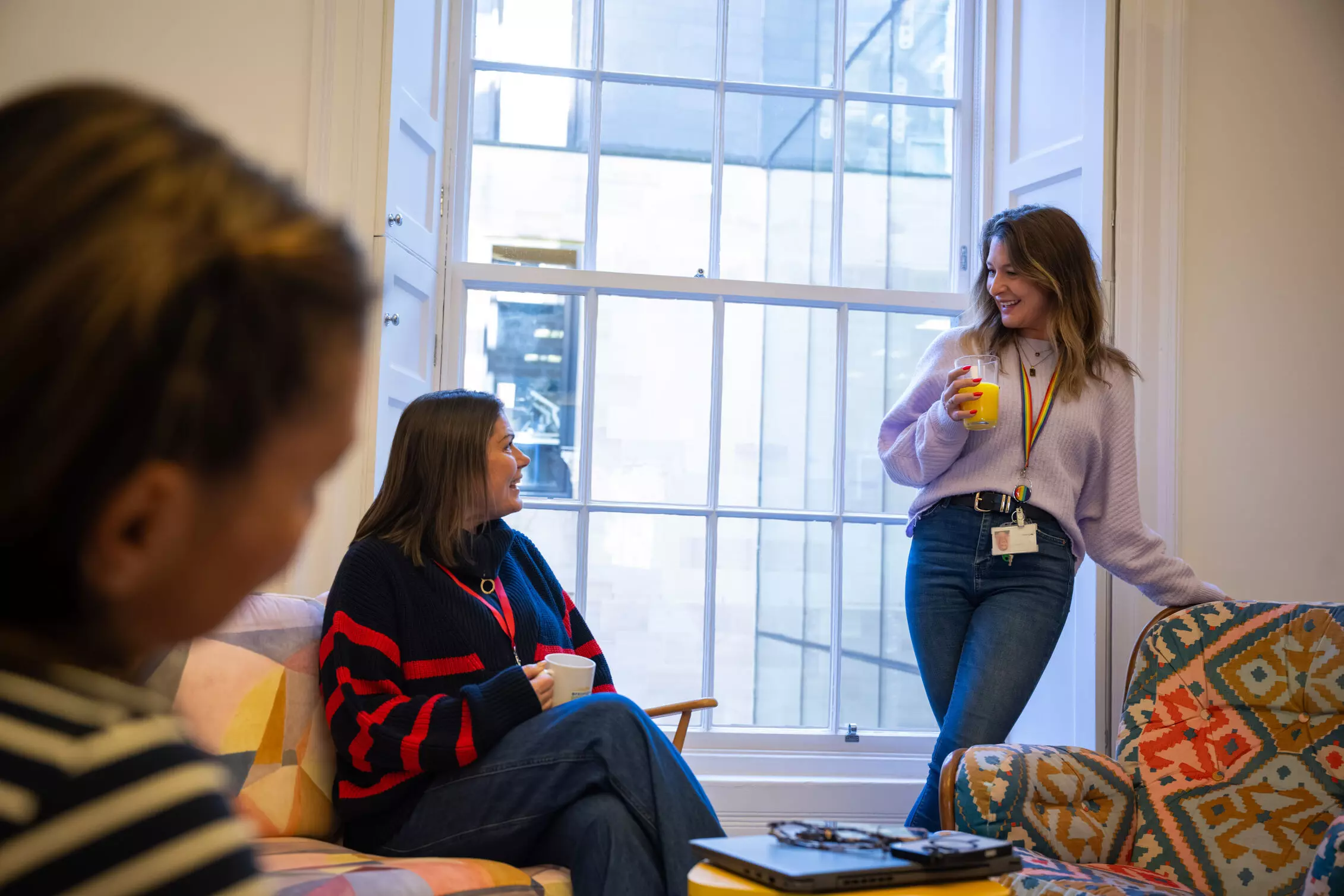 Tech A group of employees sitting around a table in an office meeting room.